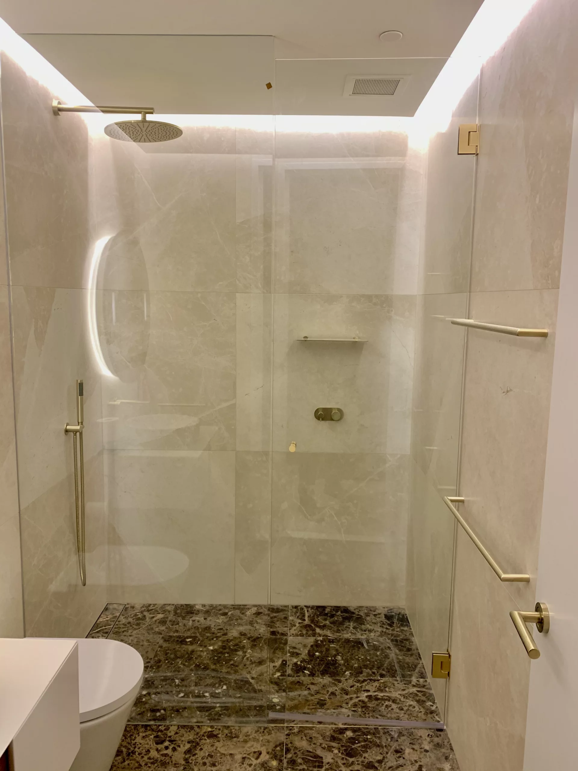 Wall to wall shower screen with brushed brass fittings